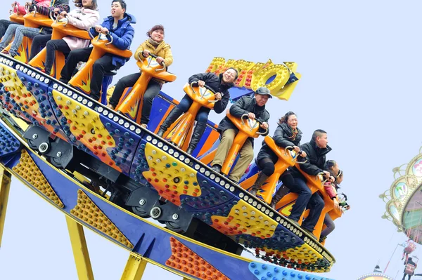 Glada människor spela Ufo Rider i en nöjespark — Stockfoto