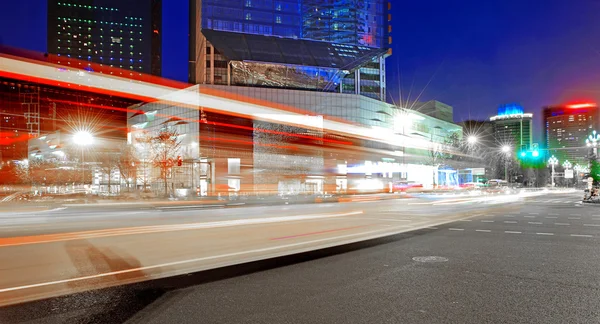 High speed and blurred bus light trails in downtown nightscape — Zdjęcie stockowe