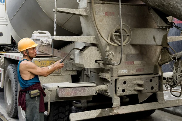 Hardworking laborer and truck-concrete mixer on construction site — Stock Photo, Image