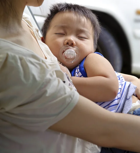 Gelukkig baby slapen in de armen van zijn moeder — Stockfoto