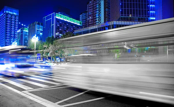 高速、都心の夜景でぼやけたバス光の道 — ストック写真