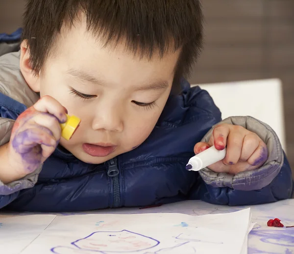 Een schattige baby is schilderen op tafel — Stockfoto