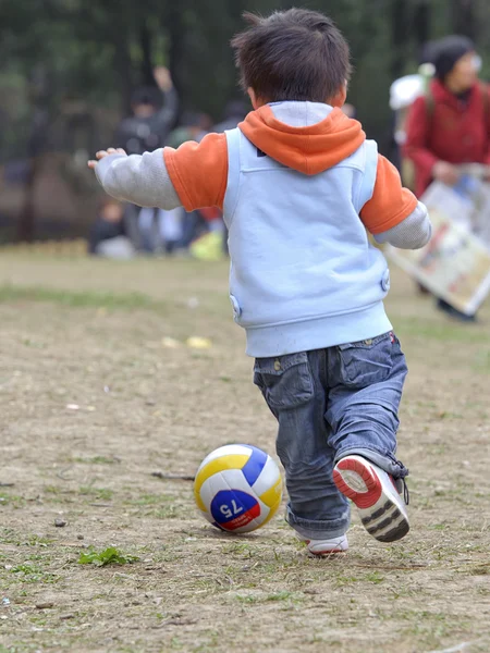 Um bebê jogando futebol — Fotografia de Stock