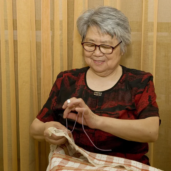 A smile sewing grandma — Stock Photo, Image