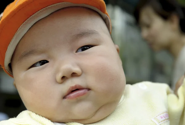 Niedliches Baby mit orangefarbener Mütze — Stockfoto