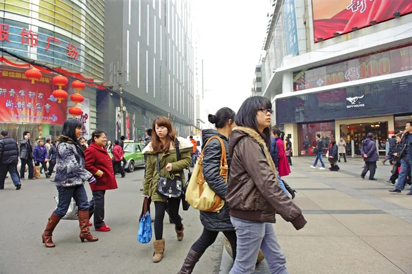 Meninas passam por uma movimentada rua comercial de pedestres — Fotografia de Stock
