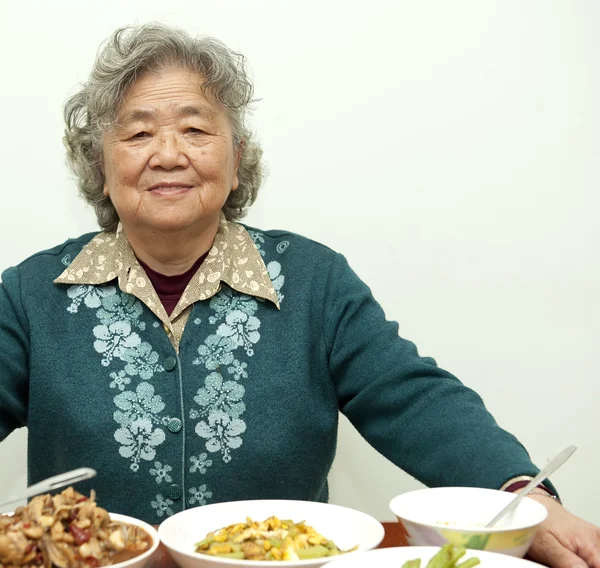 Zittend op de tafel, gelukkig grootmoeder — Stockfoto