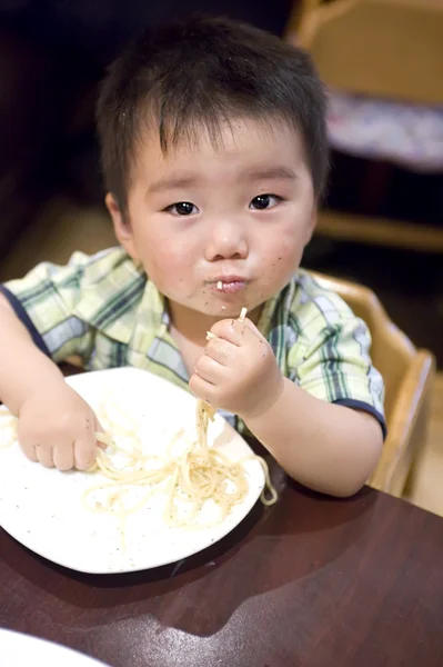 Mangiare bambino per afferrare la pasta — Foto Stock