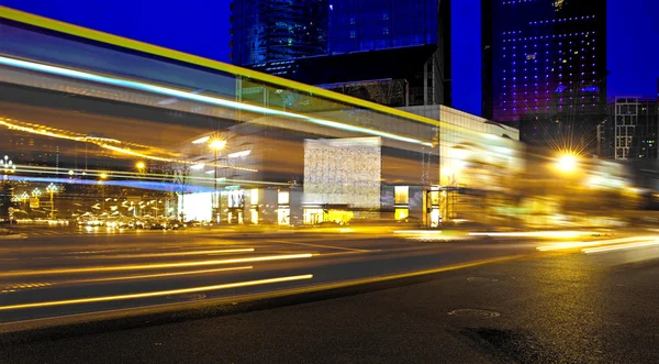 High speed and blurred bus light trails in downtown nightscape — Stock Photo, Image