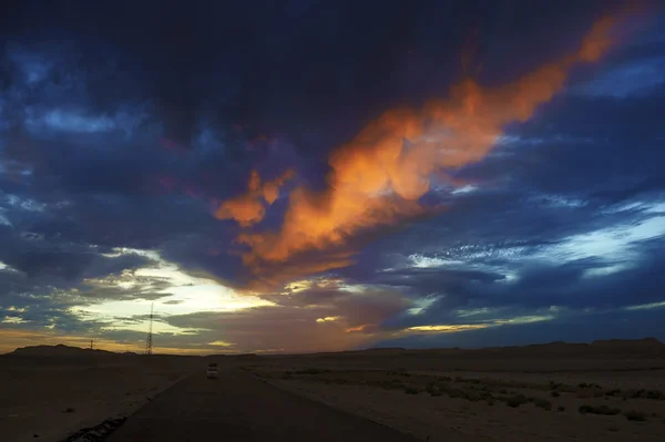 Nuvens carmesim ao pôr do sol com coloração vívida sobre o deserto do Saara — Fotografia de Stock