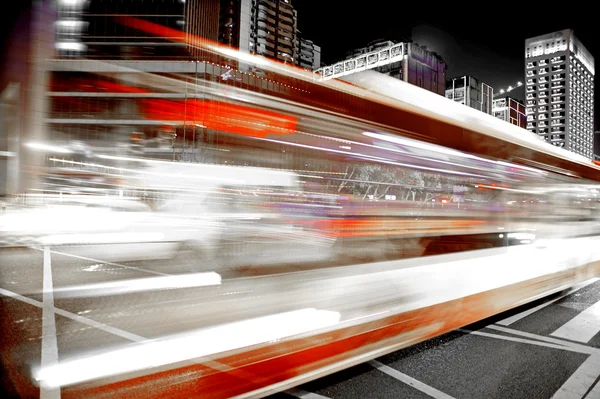 Rutas de luz de autobús borrosas y de alta velocidad en el paisaje nocturno del centro —  Fotos de Stock