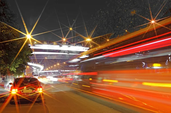 High-speed vehicles blurred trails on urban roads under overpass Stock Photo