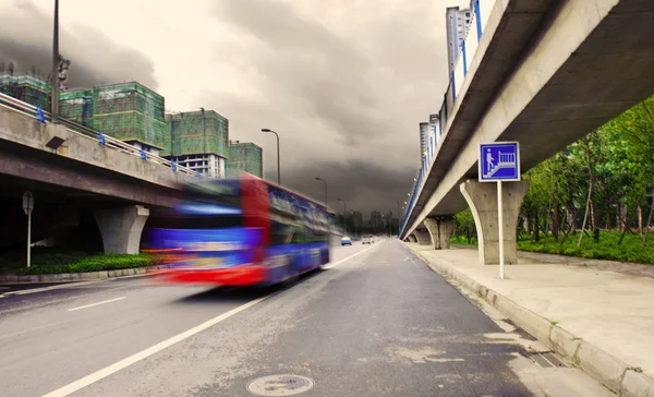 Véhicules à grande vitesse sentiers brouillés sur les routes urbaines sous le passage supérieur — Photo