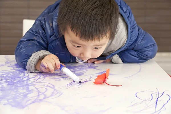 Un bambino carino sta dipingendo sul tavolo — Foto Stock
