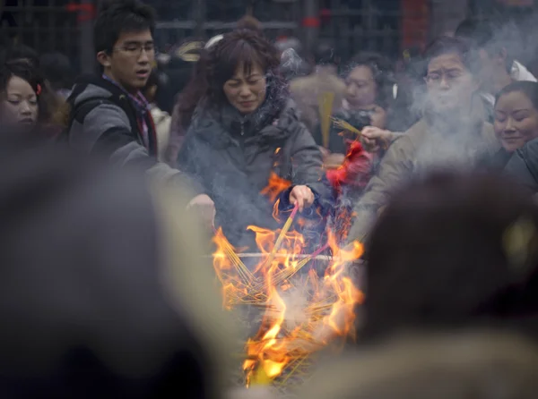 People burning incense upon the incense altar in temple — Stock Photo, Image