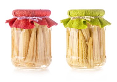 Beyaza izole edilmiş cam kavanozda korunmuş küçük mısır kulakları.