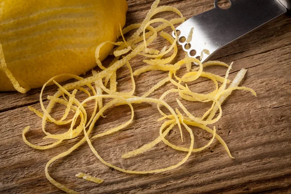 Scorza di limone e Zester su tavola di legno — Foto Stock