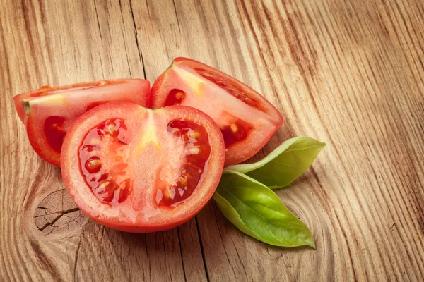 Kawałek świeżego pomidora na drewnianym stole — Zdjęcie stockowe