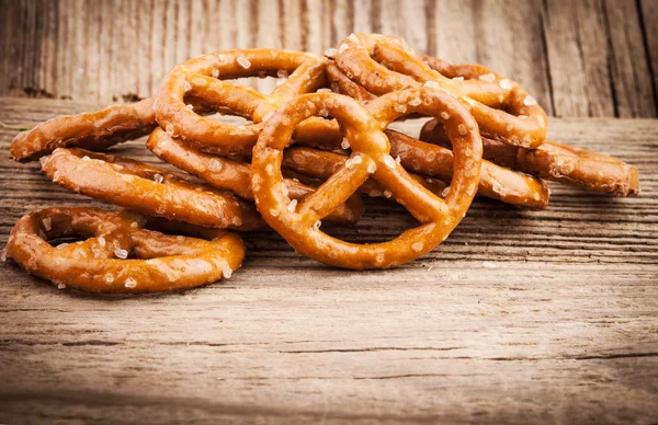 Salgado pretzel lanches no velho fundo de madeira — Fotografia de Stock