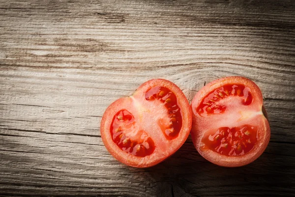 Verse tomaat helften op houten tafel — Stockfoto