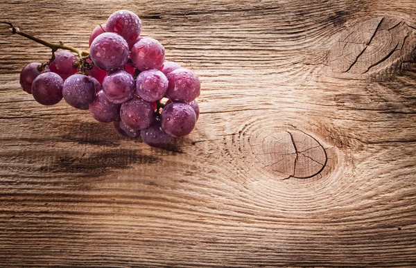 Rode druif op houten tafel — Stockfoto