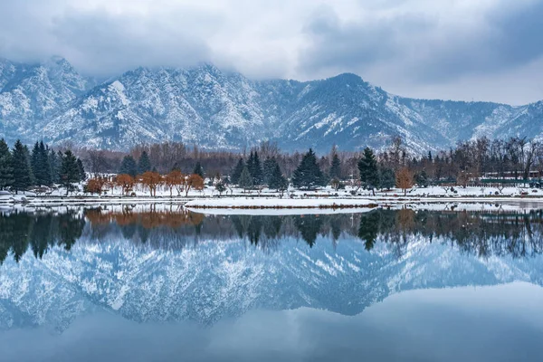 A view of botanical garden with lake in winter season, and the beautiful mountain range in the background in the city of Srinagar, Kashmir, India