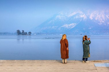 Hindistan 'ın başkenti Kaşmir' deki Dal Gölü 'nde Char Chinar' ın önünde eğlenen iki yerli Kaşmir 'li kadın..