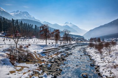 Kış mevsiminde Pahalgam 'ın güzel manzarası. Etrafı donmuş Himalayalar, buzullar, yeşil köknar ve çam ağaçları ve orman manzaralarıyla çevrili.