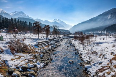 Kış mevsiminde Pahalgam 'ın güzel manzarası. Etrafı donmuş Himalayalar, buzullar, yeşil köknar ve çam ağaçları ve orman manzaralarıyla çevrili.