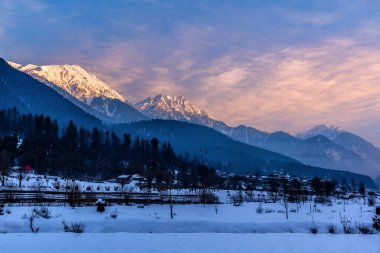 Kış mevsiminde Pahalgam 'ın güzel manzarası. Etrafı donmuş Himalayalar, buzullar, yeşil köknar ve çam ağaçları ve orman manzaralarıyla çevrili.
