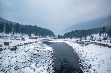 Kış mevsiminde Pahalgam 'ın güzel manzarası. Etrafı donmuş Himalayalar, buzullar, yeşil köknar ve çam ağaçları ve orman manzaralarıyla çevrili.