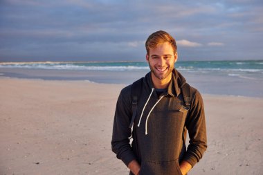 Spor haberlerinde gün doğumunda sahilde duran genç adam formalı ve mutlu görünüyor.