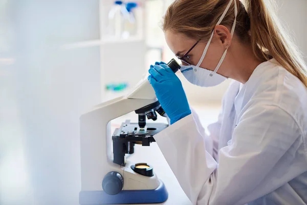 Vrouw Lab Technicus Analyseren Van Monsters Met Een Microscoop Tijdens Stockafbeelding