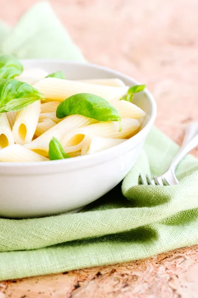 Macaroni and basil leaves — Stock Photo, Image