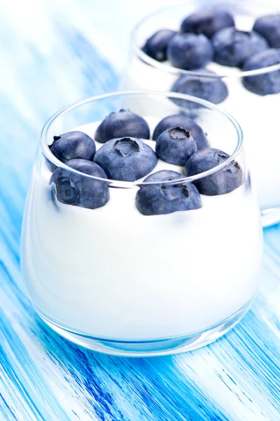 Mirtillo e yogurt sul tavolo blu — Foto Stock