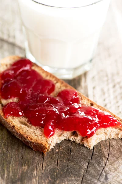 Pan con mermelada de fresa y vaso de leche — Foto de Stock