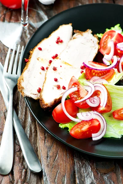 Carne di maiale al forno in piatto con insalata — Foto Stock