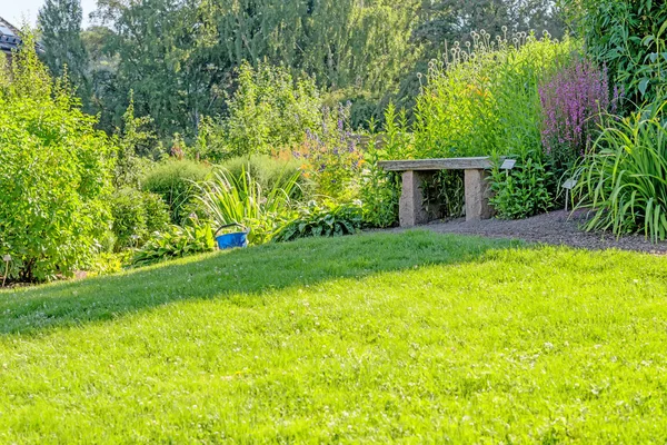 Каменная скамейка на зеленом поле — стоковое фото