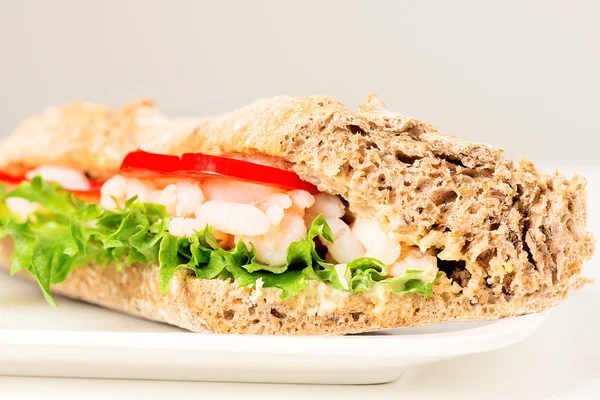 Garnaal sandwich op wit bord — Stockfoto
