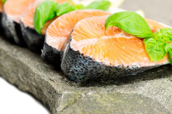 Salmon on stone with basil and lemon — Stock Photo, Image