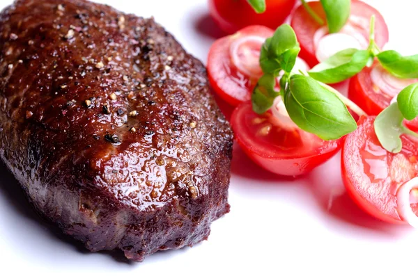 Bife grelhado com tomate e folhas de orégano — Fotografia de Stock