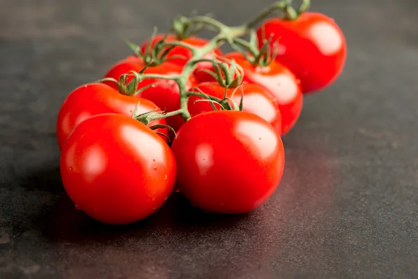 Tomatoes on dark table — Stock Photo, Image