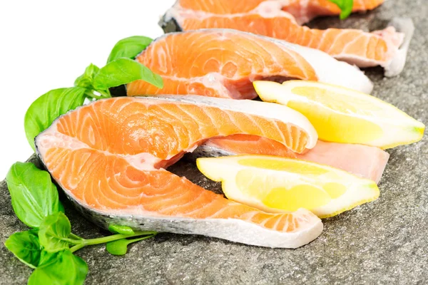 Salmon on stone with basil and lemon — Stock Photo, Image