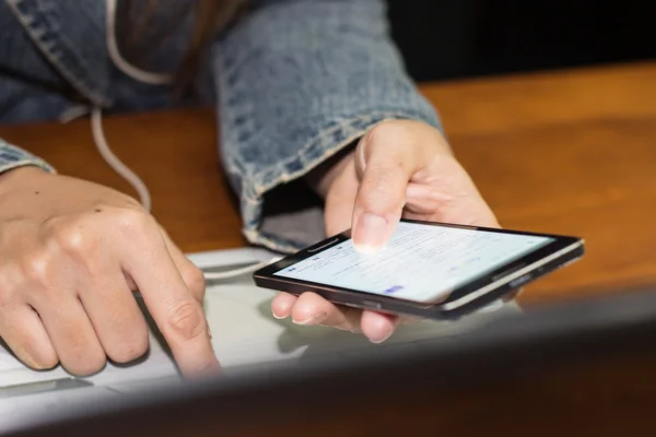 Frau nutzt Smartphone und Notebook — Stockfoto