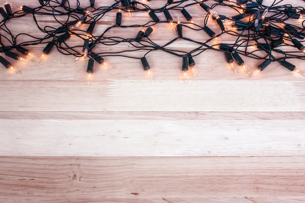 Luzes de Natal, luzes de guirlanda no fundo de madeira — Fotografia de Stock