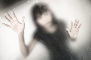 Lekeli veya kirli pencere cam arkasındaki kadın