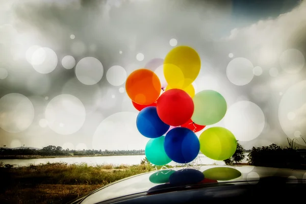 Colorful balloons on car roof — Stock Photo, Image