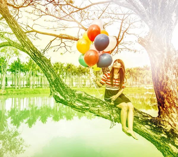 Kvinna med färgglada ballonger i parken — Stockfoto