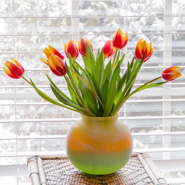 Hermosos tulipanes en jarrón en la mesa cerca de la ventana . —  Fotos de Stock