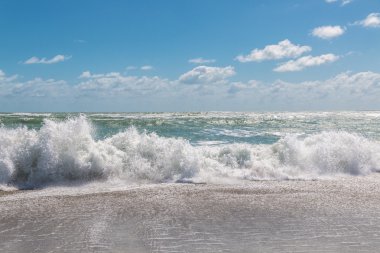 Mavi gökyüzü ve fırtınalı Atlantik Okyanusu.
